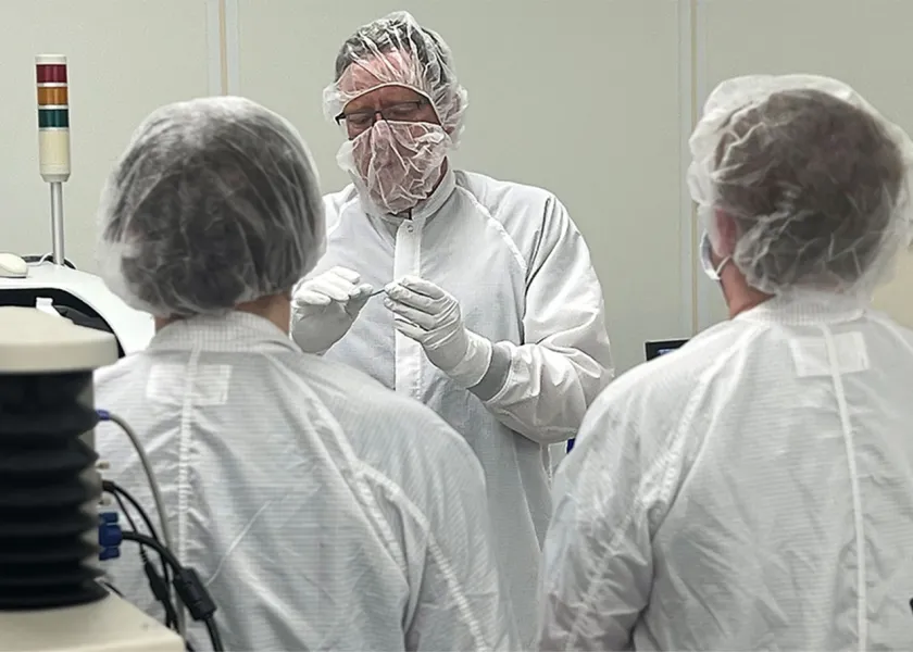 A researcher shows NDSU's clean room suite to a group of students