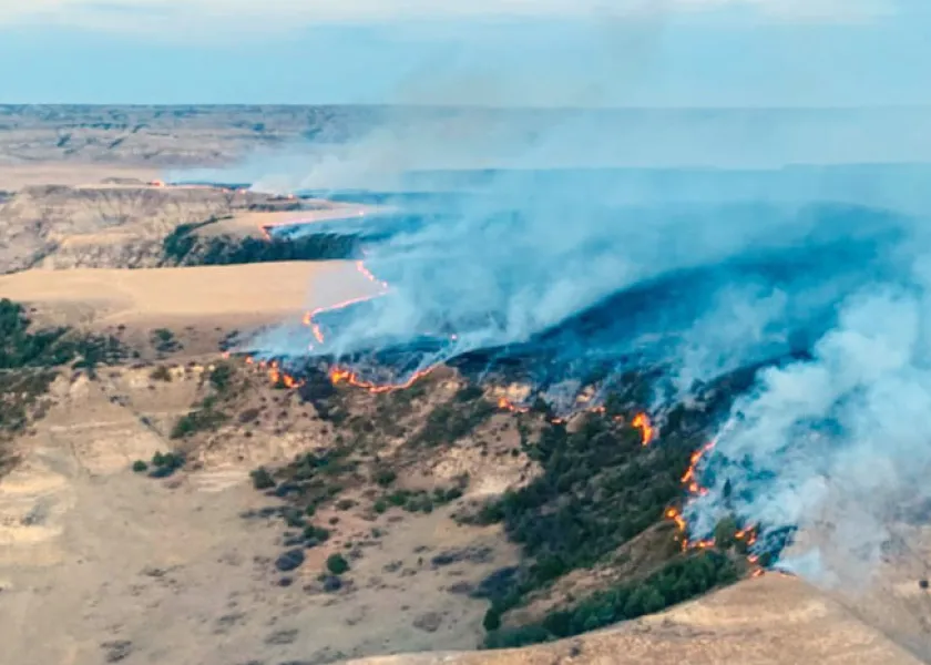 A fire burns along a butte in the badlands