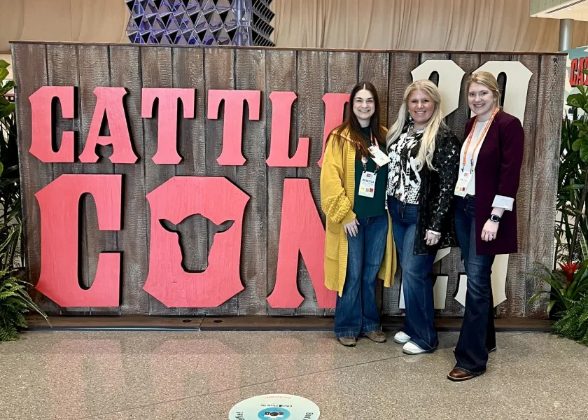 Attendees in front of Cattlecon sign
