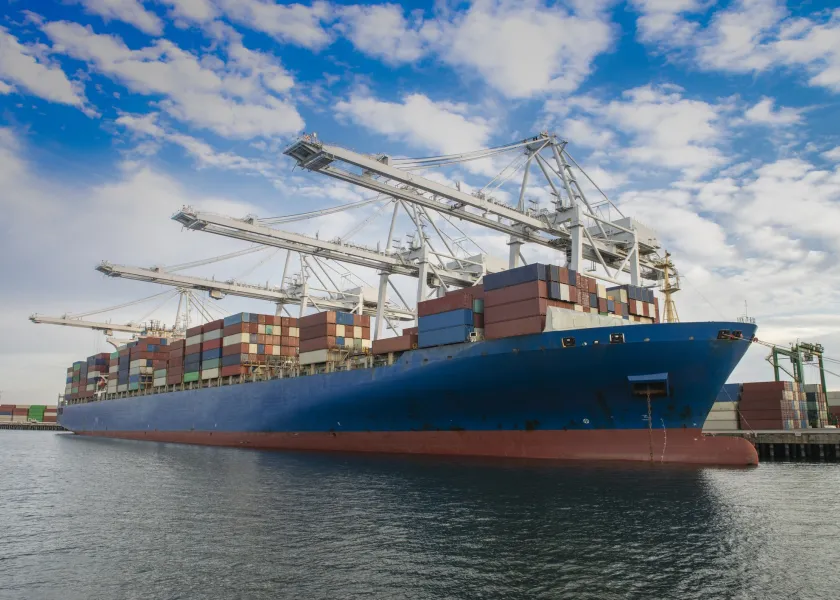 A cargo ship carries stacks of containers.