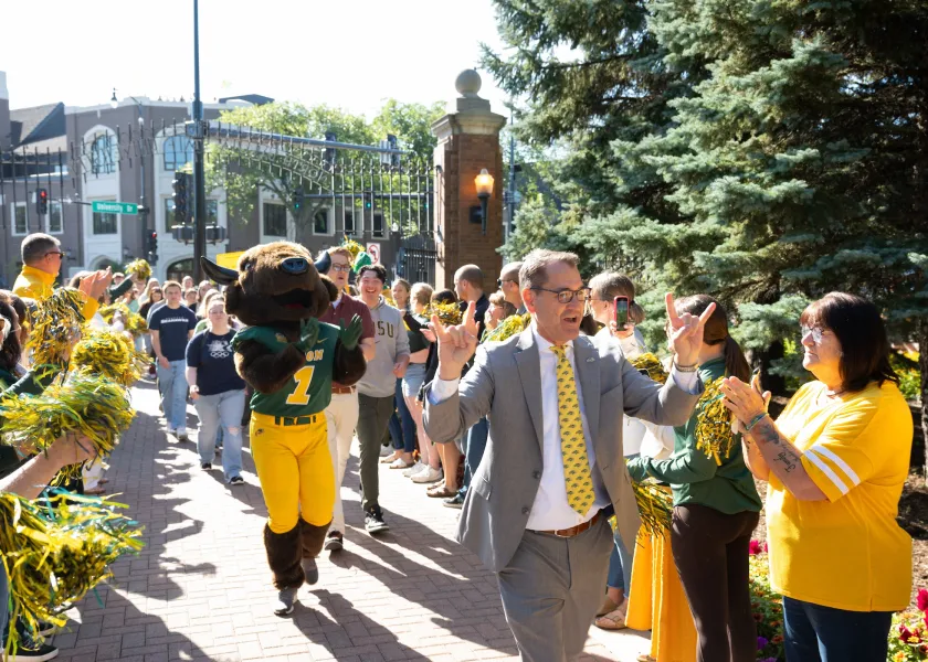 NDSU President David Cook walks incoming students through the university gates.