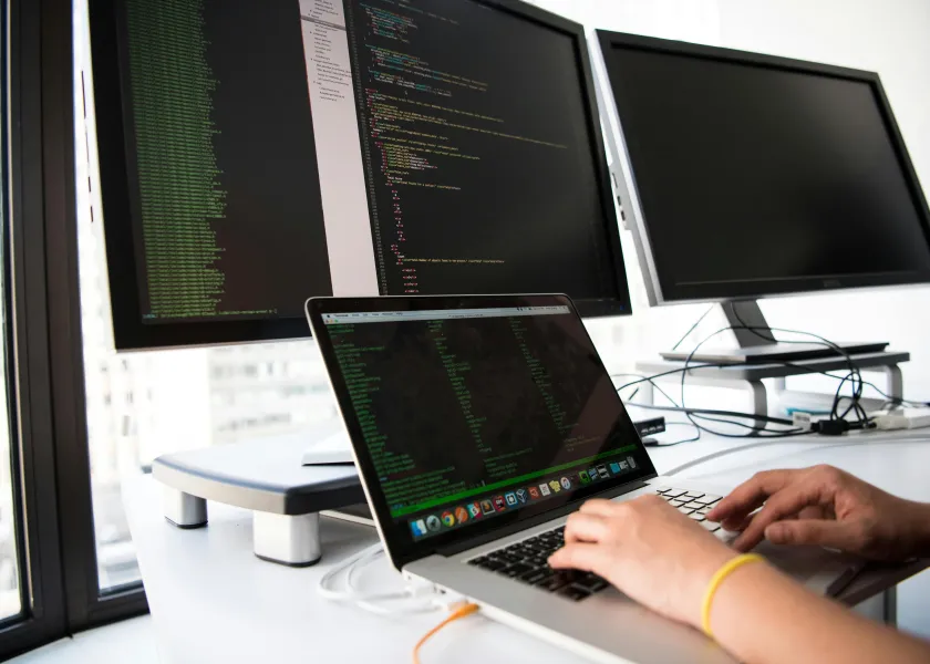 person using multiple computer screens