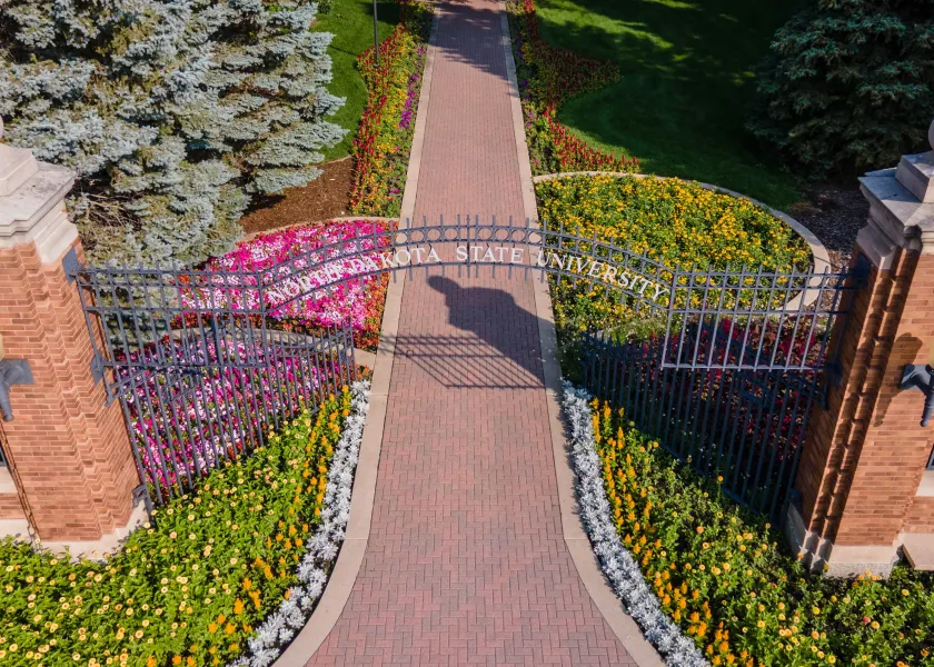 An overview of NDSU's main gates located on the corner of 12th Ave and University.