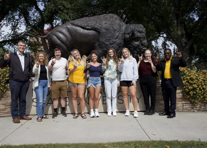 The six graduate students in NDSU’s Center for Agricultural Policy and Trade Studies stand in front of the Bison statue. 