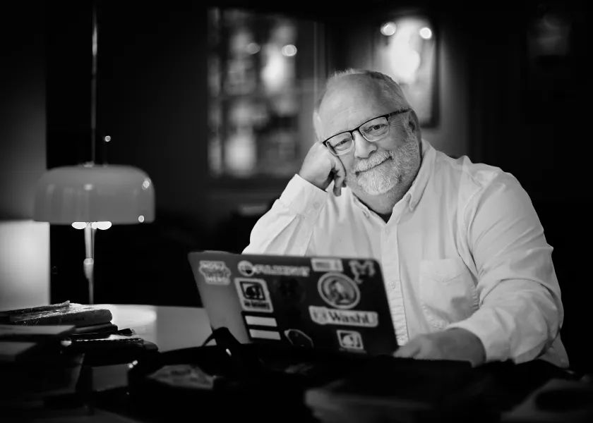 John Cox, NDSU professor of history, sits in front of his laptop.