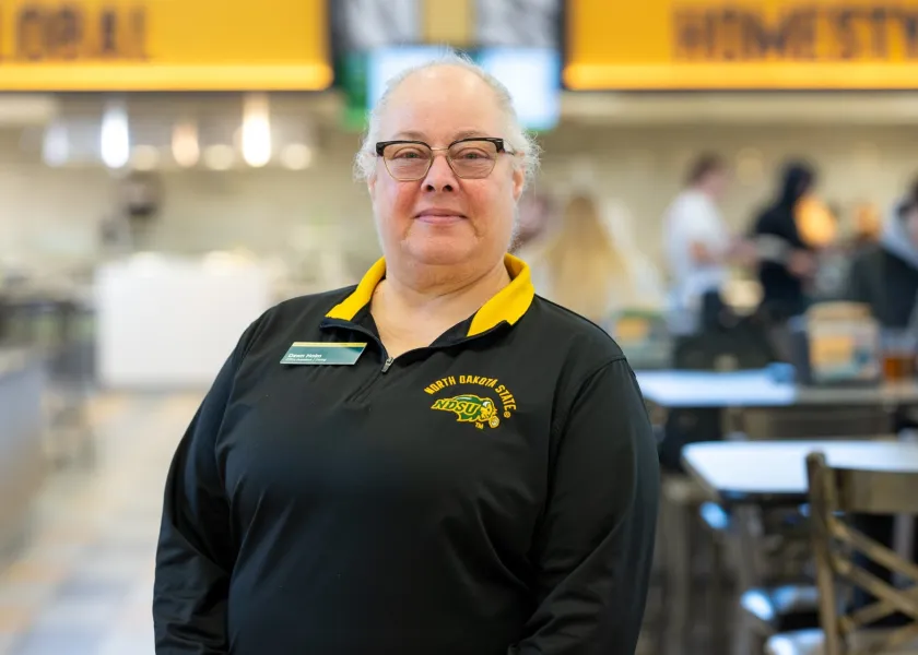 Dawn Holm, an office assistant with NDSU Dining, stands in the Residence Dining Hall.