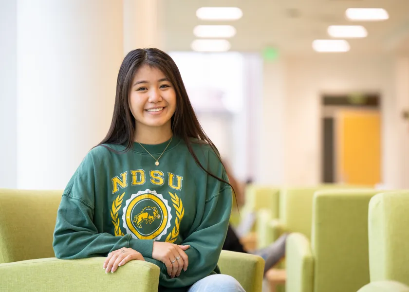 NDSU student Sarah Kruse, a senior majoring in biology and statistics, poses for a photo while sitting on a chair in the A. Glenn Hill Center. 