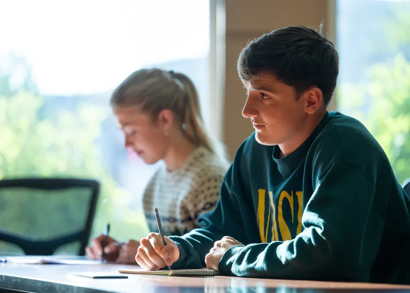NDSU students listen and take notes during a lecture in a classroom in Barry Hall.