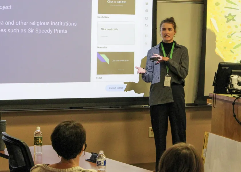 An NDSU student stands in front of a crowd to present their project.
