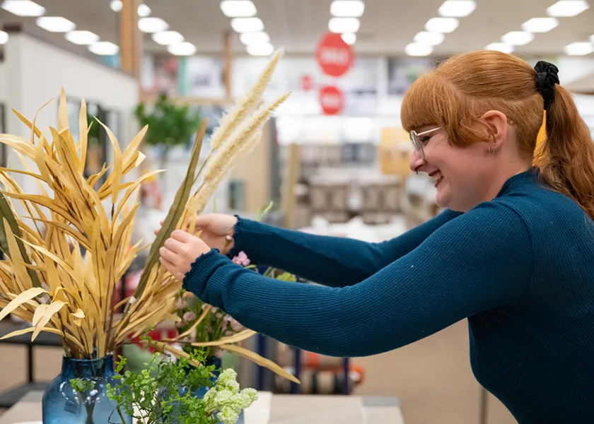 an NDSU student works on a flower arrangement as part of a project