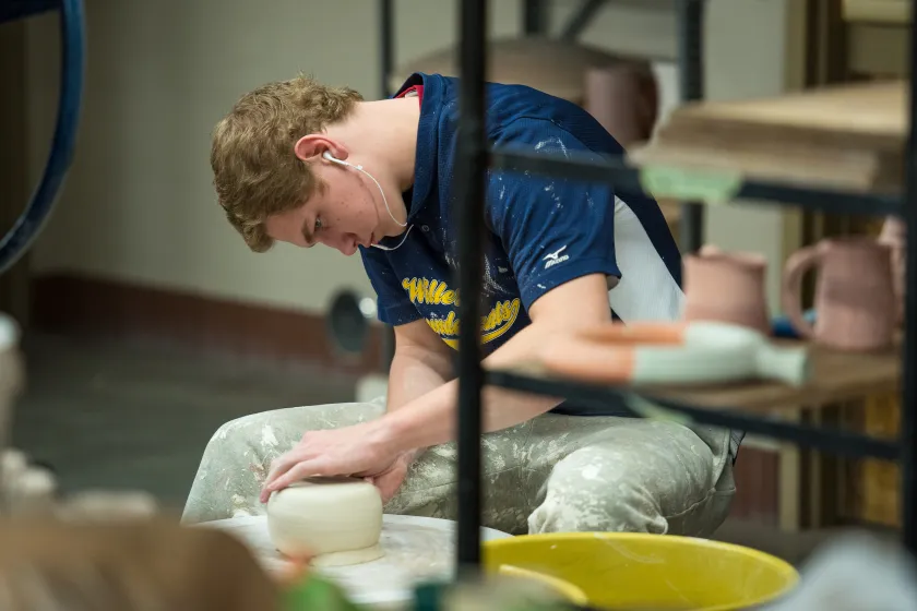 An NDSU student makes pottery in a studio.