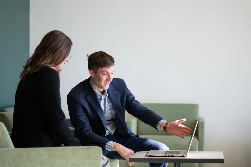 students in Health Services having a discussion and looking at a laptop
