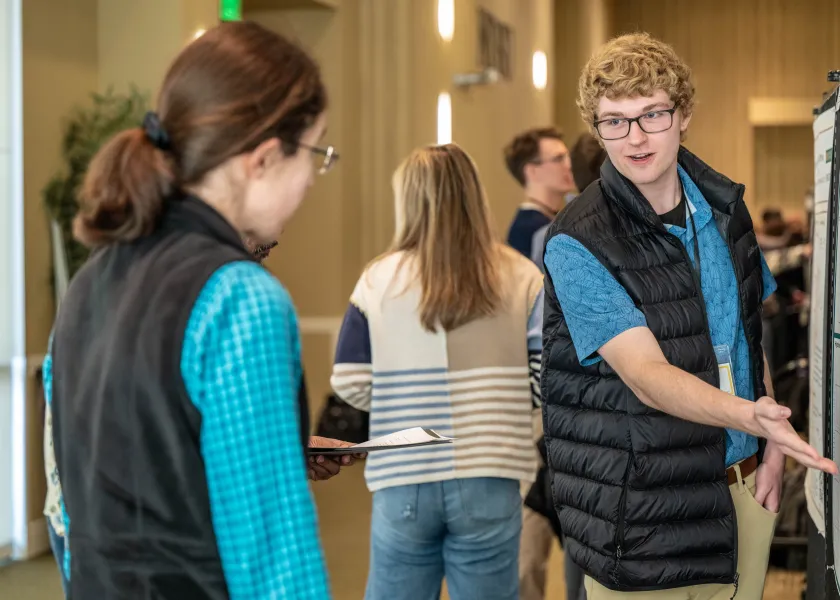 An NDSU undergraduate student talks about his research in the NDSU Memorial Union.
