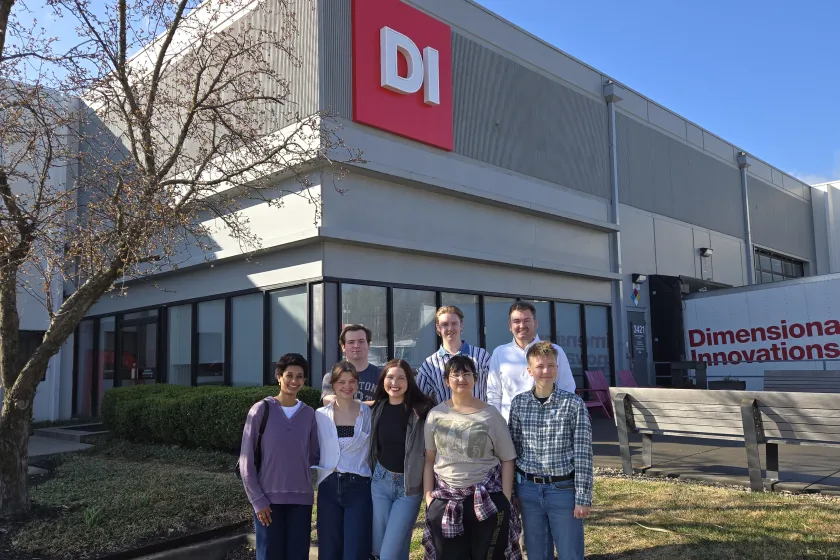 NDSU students pose for a photo in front of Dimensional Innovations.