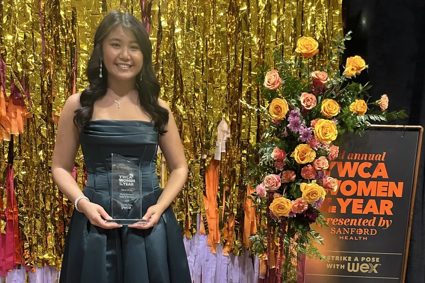 Sarah Kruse, a senior majoring in biology and statistics, poses for a photo while holding her YWCA award.