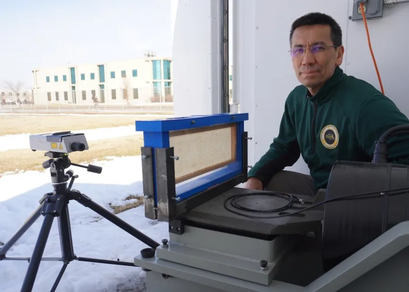Sulaymon Eshkabilov, NDSU assistant professor of ag machinery engineering, poses for a photo by a laser scanning vibrometer. 