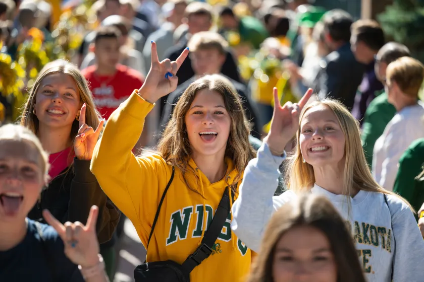 NDSU students dressed in NDSU gear pose for a photo.