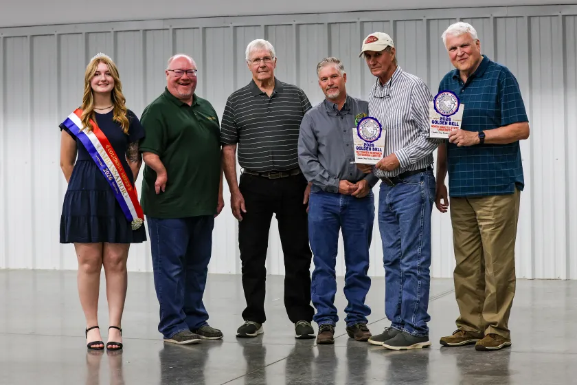 A group of people hold the Golden Bell Award.
