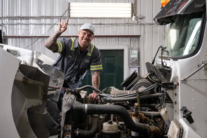 NDSU alum Josh Seley, poses for a photo by a semi in his business.