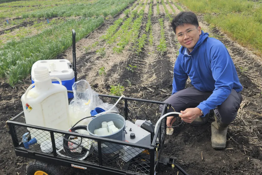 Kang Liang with equipment in the field