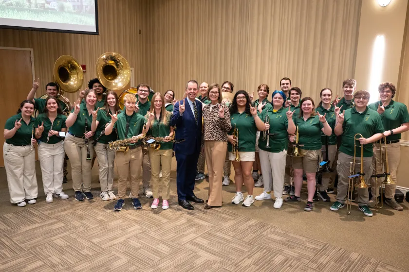 President Stewart and Jan pose with the Gold Star Marching Band during the annoucement event