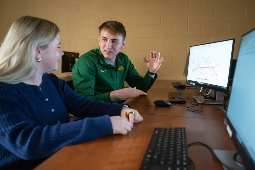 students discuss charts on the computer during a Business class