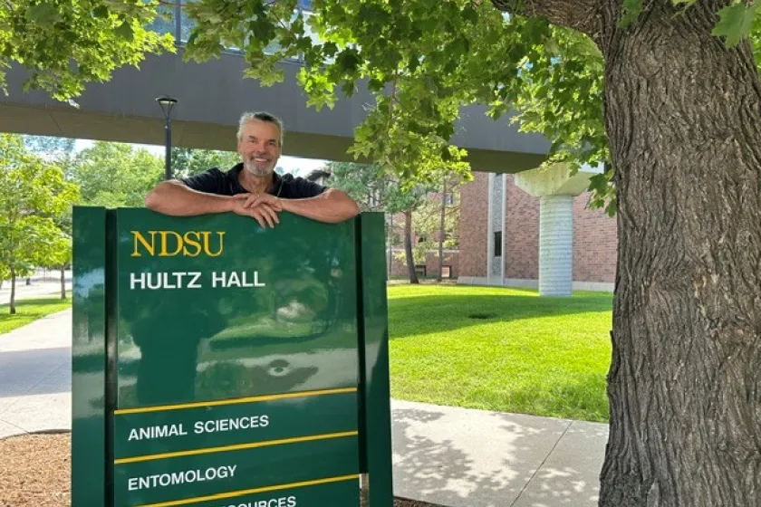 Dr. Eric Berg stands by Hultz Hall sign