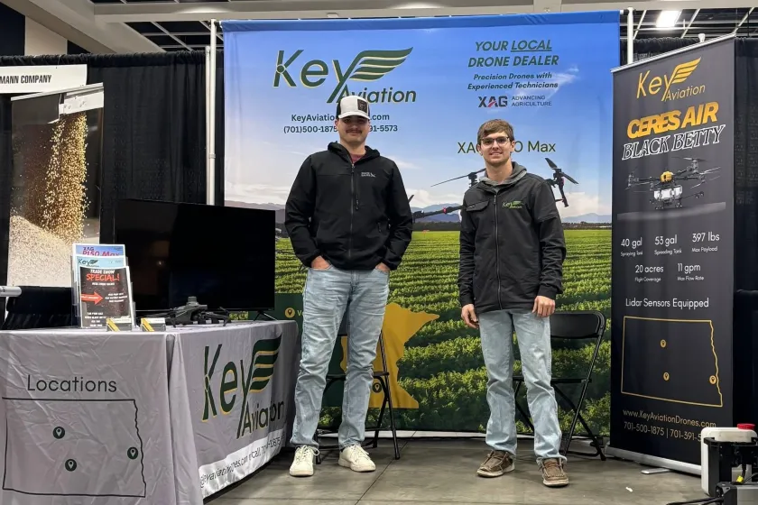 Two NDSU students stand next to each other at a booth with the sign Key Aviation