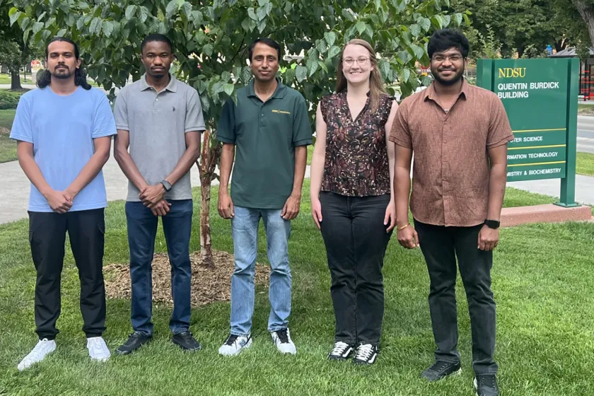 NDSU graduate students stand next to each other outside.