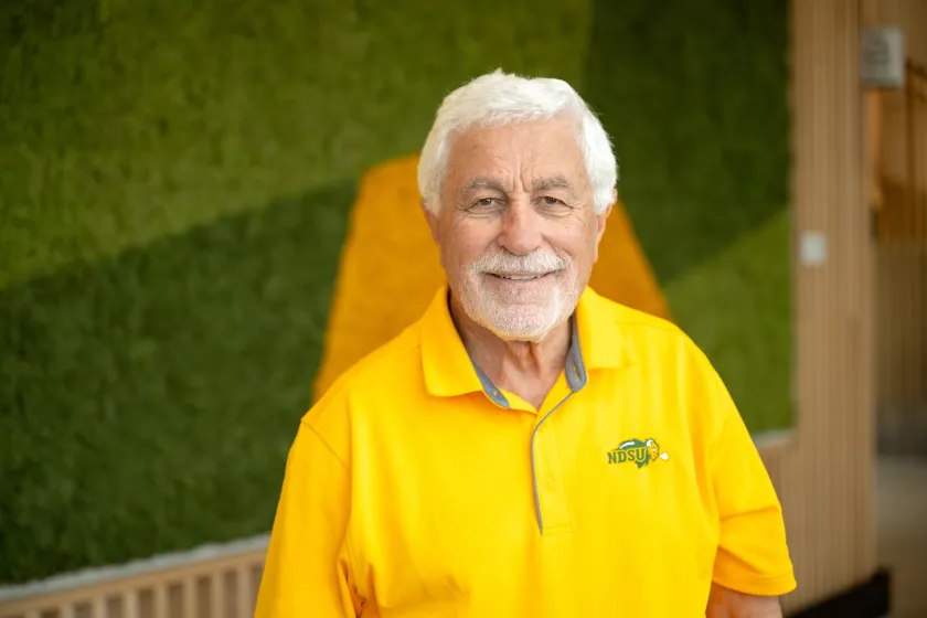 A man in a yellow polo smiles