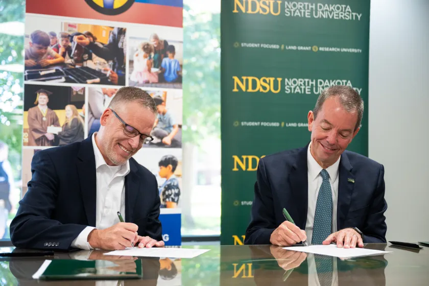 Fargo Public Schools District Superintendent Cory Steiner and NDSU President Marshall Stewart sign partnership for Teacher Leadership Academy.