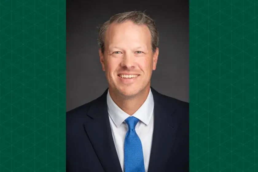 Headshot of Brody Maack with a green textured background on either side