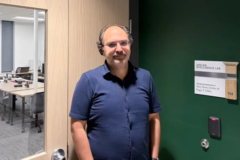 Harun Pirim posing outside a lab room