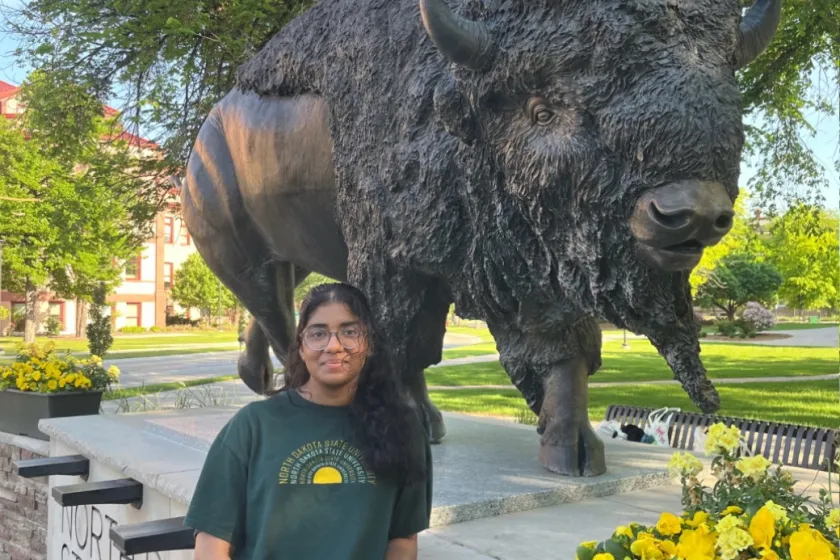 Lena Joshy stands beside the Bison statue