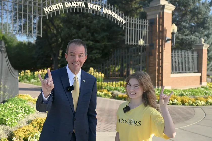 man and woman in front of ndsu gates