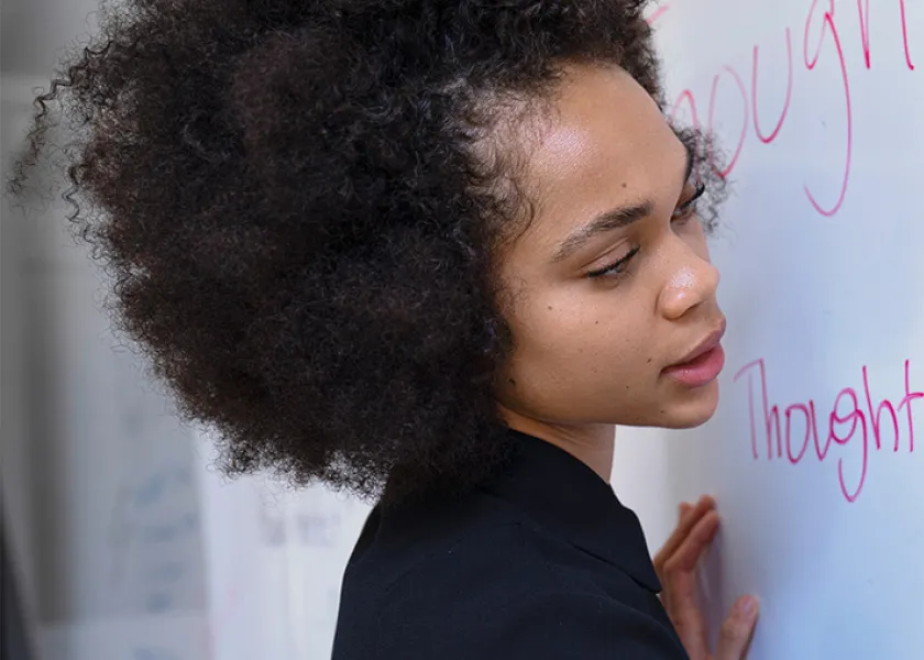Educator writing on a white board.