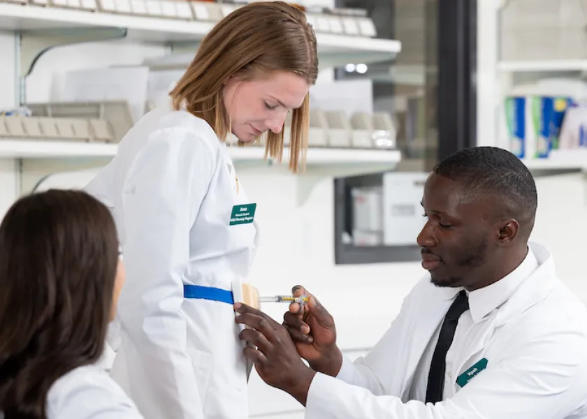 faculty working with student in a pharmacy