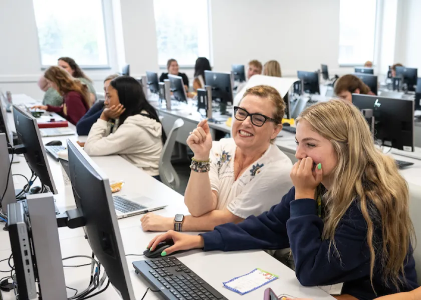 faculty working with student in a computer lab setting