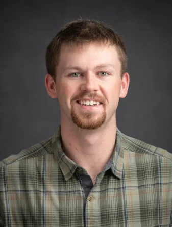 A man with a goatee smiling