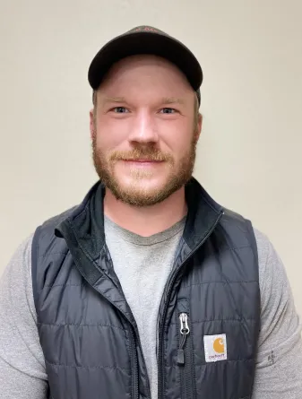 A man with a beard and a ball cap smiling