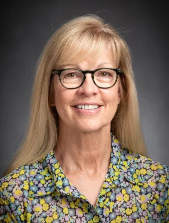 Polly Olson smiling confidently at the camera.