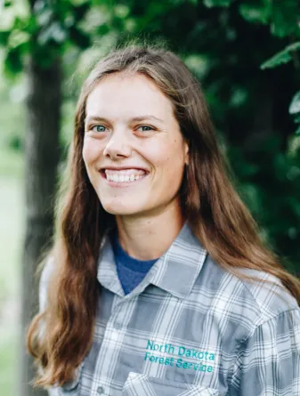 A woman with long brown hair smiles
