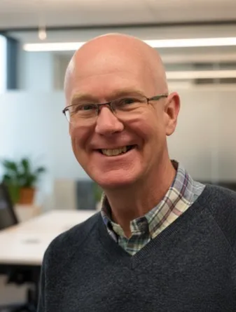 Benna smiling confidently at camera.