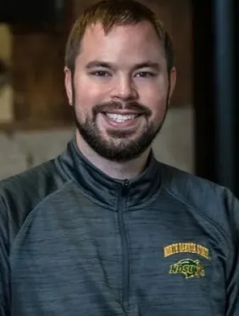 A smiling man wearing a North Dakota State University zip up jacket.