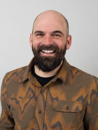 Josh Zeis looking confidently at the camera with a big smile.