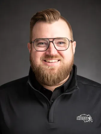 Headshot of Jordan Bonstrom in a black quarter-zip 