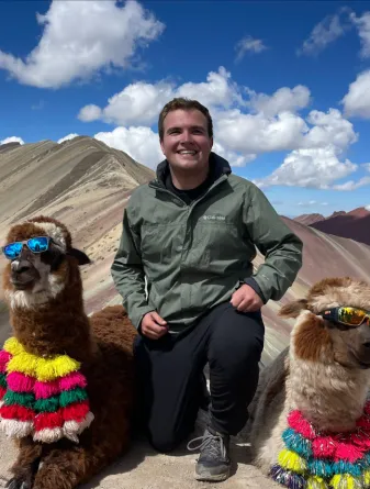 Student in between two llamas