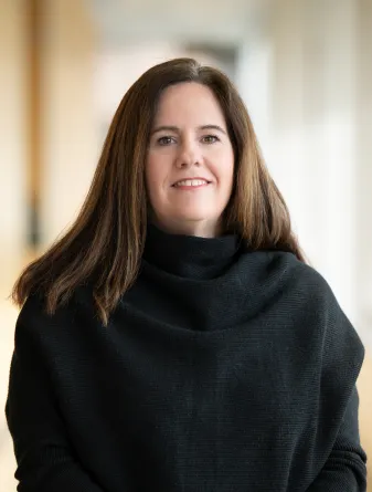 Headshot photo of a woman with dark hair and a black top
