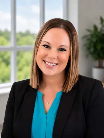 Erika is a caucasian middle ages woman with straight brown hair and brown eyes. She is wearing a turquoise shirt with a black blazer. 
