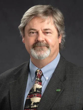 Man in blue shirt and grey jacket